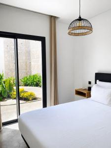 a bedroom with a white bed and a large window at Riba D'Mar - B in Machico