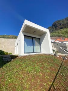a house on top of a grassy yard at Riba D'Mar - B in Machico