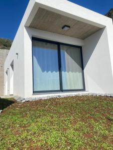 a house with a large window on top of a yard at Riba D'Mar - B in Machico +21 photos