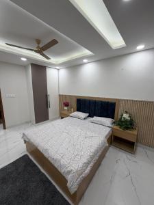 a bedroom with a large bed and a ceiling at The Green Hush in Rājpur