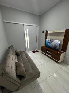 a living room with a couch and a flat screen tv at Casa da Vá! in Jijoca de Jericoacoara