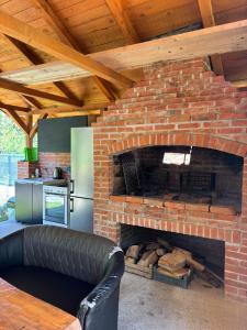 a brick fireplace in a kitchen with a black couch at Pure Nature in Bihać