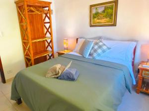 a bedroom with a blue bed with a hat on it at Quinta essência suites e chalés in Ubatuba
