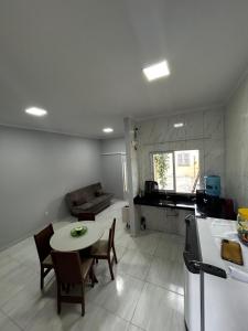 a kitchen and living room with a table and chairs at Casa da Vá! in Jijoca de Jericoacoara