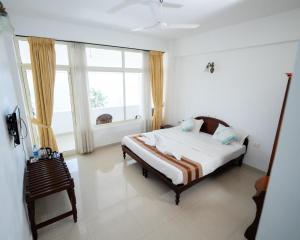 a bedroom with a bed and a large window at Swapnatheeram Beach Resort in Kovalam