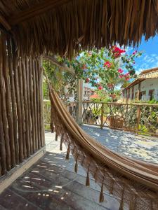 a hammock in a resort with flowers in the background at Beco do Mar Jeri in Jericoacoara