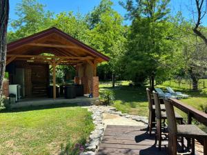 a pavilion with a picnic table and chairs in a park at Pure Nature in Bihać