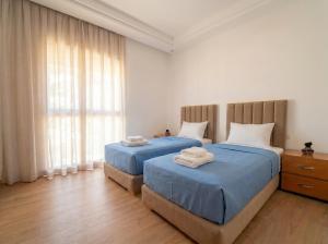 a bedroom with two beds with towels on them at Ocean View Duplex & Golf, Taghazout Bay in Tamraght Ouzdar +42 photos