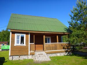 una pequeña casa de madera con techo verde en Cottages Mantiansaari en Lunkulansaari