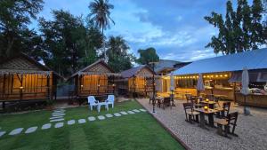 a patio with tables and chairs and a restaurant at Bamboo Khiri in Sathani Rot Fai +17 photos