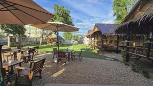 a group of tables and chairs with an umbrella at Bamboo Khiri in Sathani Rot Fai
