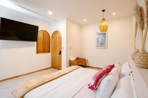 a bedroom with a large bed and a flat screen tv at Hotel Casa Eteca in San Pedro y San Pablo Etla