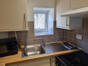 a kitchen with a stainless steel sink and a window at Kingfield Boutique Hotel in Sheffield +111 photos