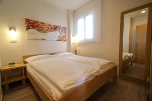 een slaapkamer met een groot bed en een spiegel bij Apartments Erica Lux in Novigrad Istria