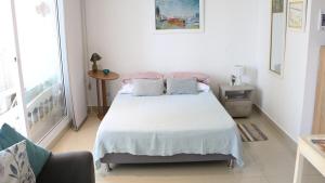 a bedroom with a white bed with two pillows on it at Corredor Suite - Eira Building - Santa Marta in Santa Marta +17 photos