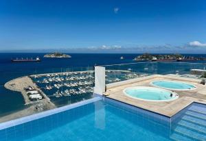 a large swimming pool with a view of the ocean at Corredor Suite - Eira Building - Santa Marta in Santa Marta