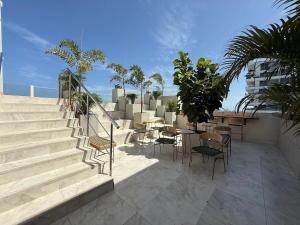 a patio with stairs and tables and chairs at Corredor Suite - Eira Building - Santa Marta in Santa Marta