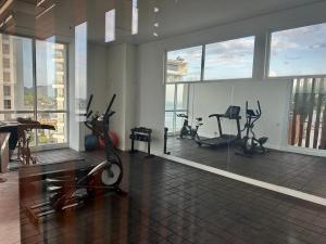 a gym with exercise equipment in a building with windows at Corredor Suite - Eira Building - Santa Marta in Santa Marta