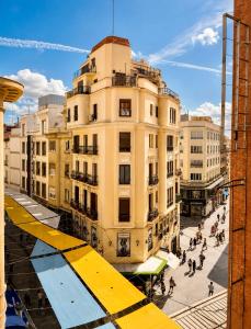 a building with a yellow awning in a city at Callao Suites in Madrid