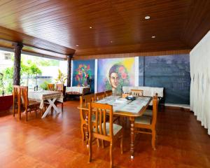 a dining room with a table and chairs and a painting at Swapnatheeram Beach Resort in Kovalam
