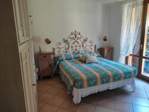 a bedroom with a bed with a blue and green comforter at Bolgheri 59 in Bolgheri
