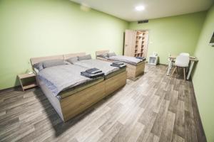 a bedroom with two beds and a wooden floor at Penzion Relax Litovel in Litovel