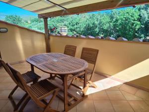 a wooden table and chairs on a balcony at Bolgheri 59 in Bolgheri