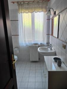 a white bathroom with a sink and a window at Bolgheri 59 in Bolgheri +9 photos
