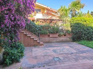 a house with a staircase and purple flowers at Bolgheri 59 in Bolgheri