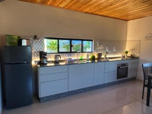 a kitchen with white cabinets and a black refrigerator at Casa Alborada Bella Vista Itapúa in Bella Vista