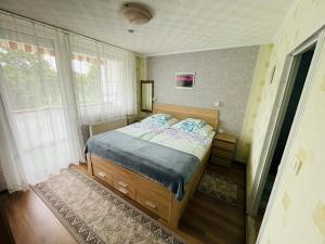 a bedroom with a bed in a room with windows at Karolin Apartman in Bükfürdő