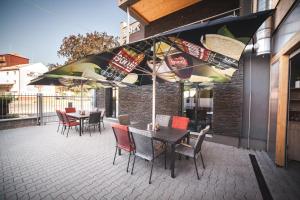 un patio con tavolo, sedie e ombrelloni di Penzion Relax Litovel a Litovel