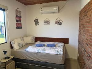 a small bed in a room with a brick wall at Casa Alborada Bella Vista Itapúa in Bella Vista