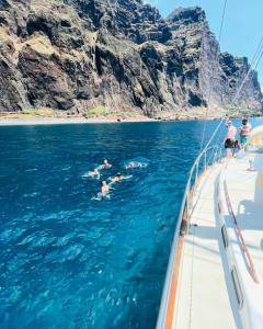 a group of people swimming in the water on a boat at Spica in Funchal