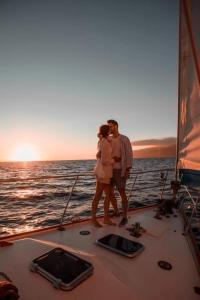 a couple standing on a sail boat in the ocean at Spica in Funchal +10 photos