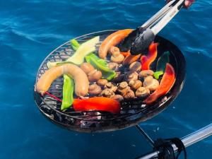 a grill with vegetables on it next to the water at Spica in Funchal