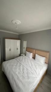 a bedroom with a large white bed with white pillows at Divan Kars Suit in Kars +6 photos