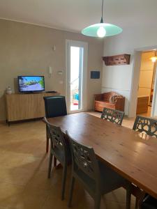 a dining room with a large wooden table and chairs at Romano Holiday 3 in Marina di Pescoluse