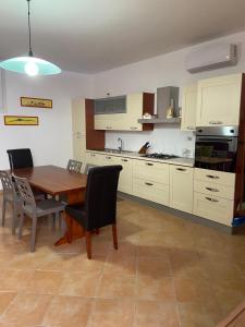 a kitchen with a wooden table and chairs and a dining room at Romano Holiday 3 in Marina di Pescoluse