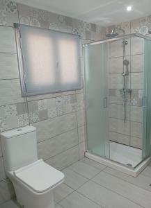 a bathroom with a toilet and a glass shower at Nikolas Aggelis rooms in Pera Gyalos +7 photos