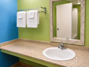 a bathroom with a sink and a mirror and towels at Seminole Inn in Donalsonville