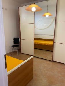 a mirror in a room with a bed and a chair at Romano Holiday 3 in Marina di Pescoluse