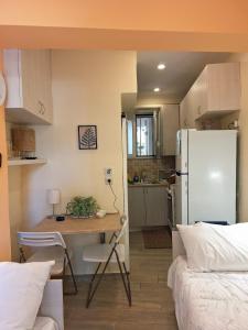 a small kitchen with a table and a refrigerator at il tesorino di Corfu in Corfu