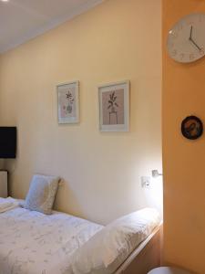 a bedroom with a bed and a clock on the wall at il tesorino di Corfu in Corfu