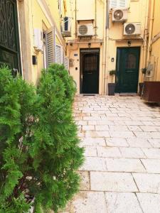 a stone walkway in front of a building with two doors at il tesorino di Corfu in Corfu