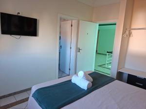 a room with a bed with a towel on it at Pousada Zamberlan in Guarujá +28 photos