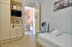 a bedroom with a bed and a dresser with a tv at Alessandro's Apartment in Mantoúkion