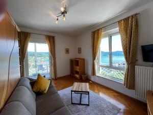 a living room with a couch and two large windows at Buchenheim Apartments in Reifnitz