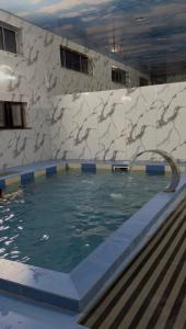 a swimming pool with a fountain in a building at Kausar cottage in Cholpon-Ata