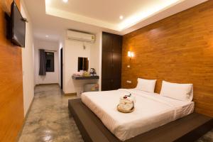 a bedroom with a bed with a wooden wall at Pagoda Sight Residence in Nan